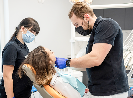 young-beautiful-girl-dentist-with-assistant-receives-treatment-with-help-latest-equipment-dentistry 1