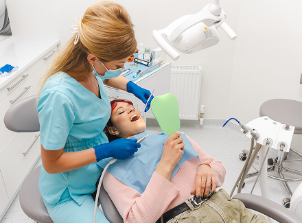 young-woman-is-lying-dentist-chair-is-getting-some-teeth-done 1